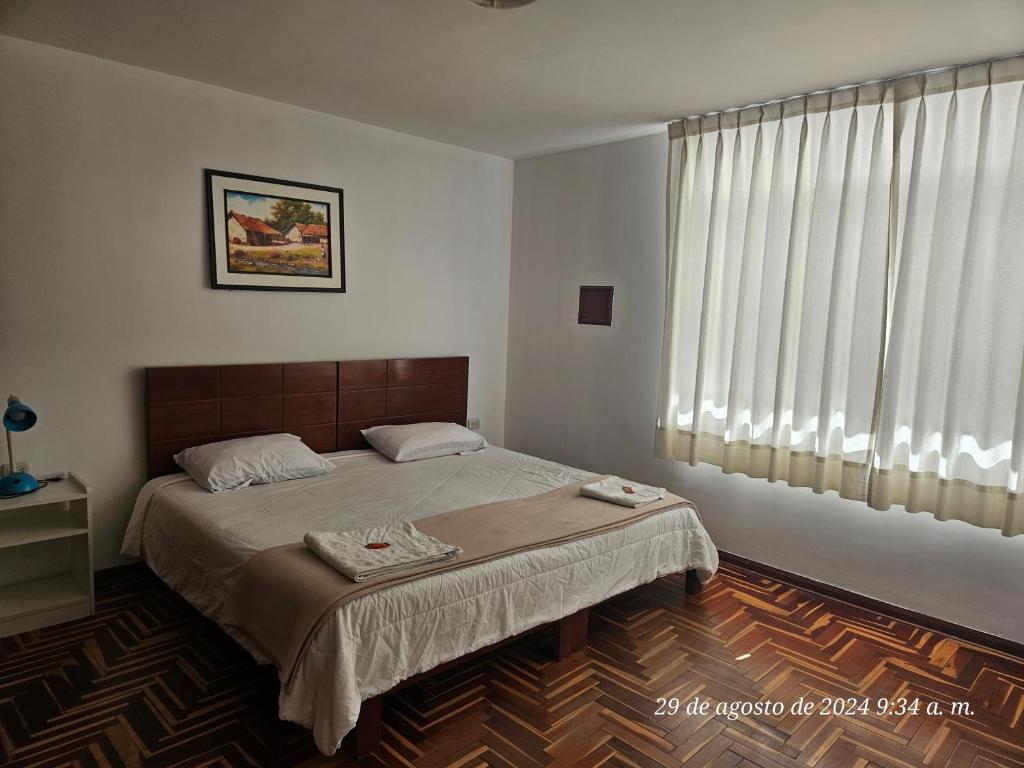 a bedroom with a bed and a large window at Departamento Los Sauces in Cajamarca