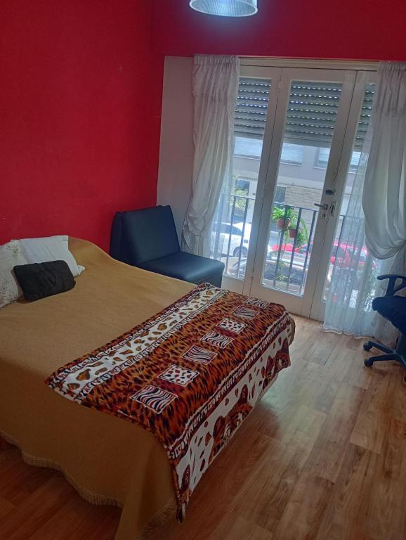 a bedroom with a bed and a chair and a window at Dpto meli in Mar del Plata