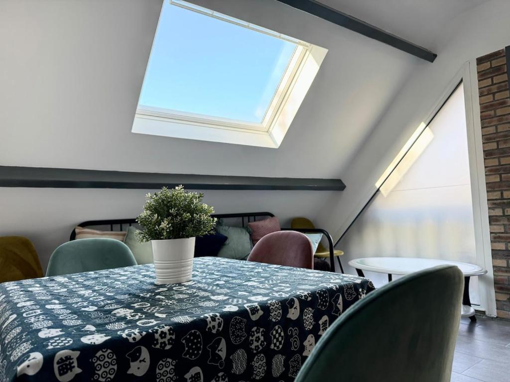 une salle à manger avec une table et des chaises et une fenêtre dans l'établissement Duplex 2 chambres proche tram, à LʼÉtang-la-Ville