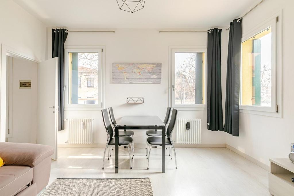 ein weißes Wohnzimmer mit Tisch und Stühlen in der Unterkunft Charme Padovano con Terrazza in Padua