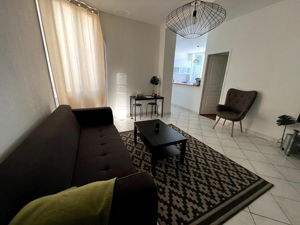 un salon avec un canapé et une table dans l'établissement Appartement paisible, à Villeurbanne