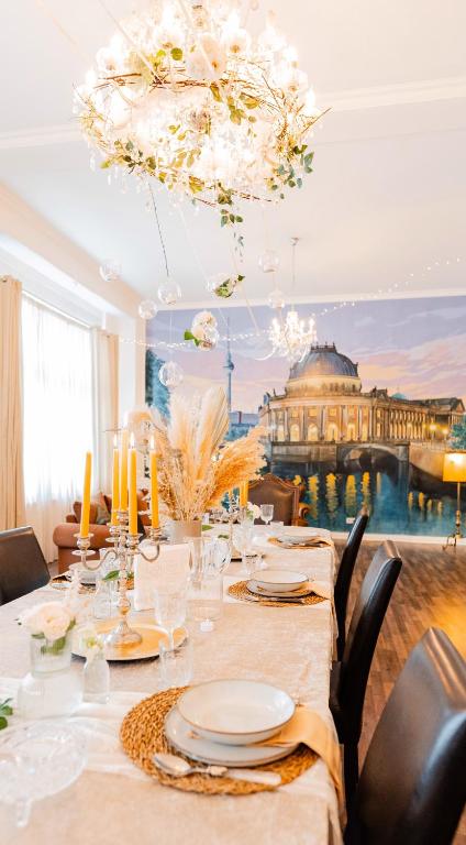 a dining room with a table with chairs and a chandelier at Apartment Prenzlauer Berg in Berlin