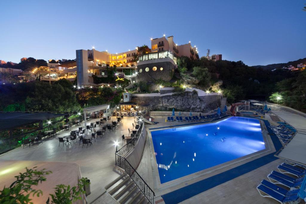 a view of a pool at a resort at night at Crystal Hotel Bodrum in Gumusluk