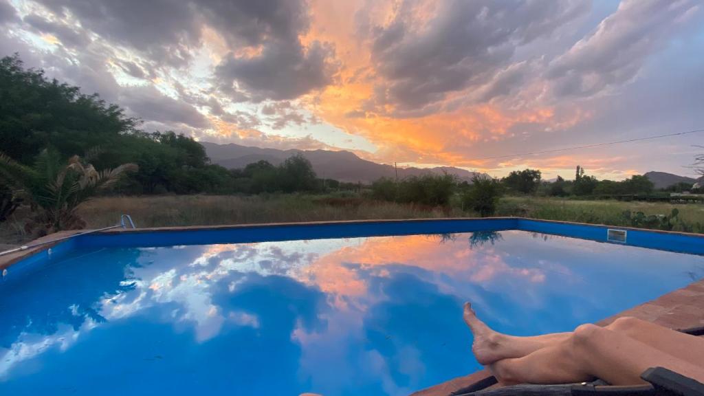 a person laying in a chair in front of a swimming pool at El Cortijo Tinogasta in Tinogasta