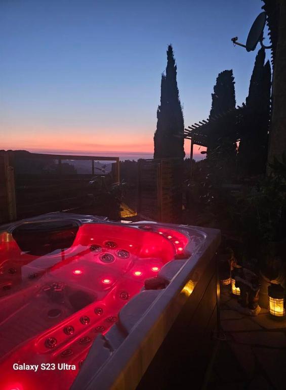 une baignoire avec des lumières rouges au milieu dans l'établissement Le Château de Soleil, à Saint-Pons-de-Mauchiens