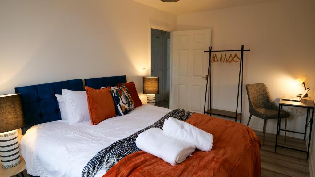 a bedroom with a large bed with two pillows on it at A Place to Pause, A Place to Belong, Charming Three Bedroom Rainham Retreat with Parking and WiFi in Swindon