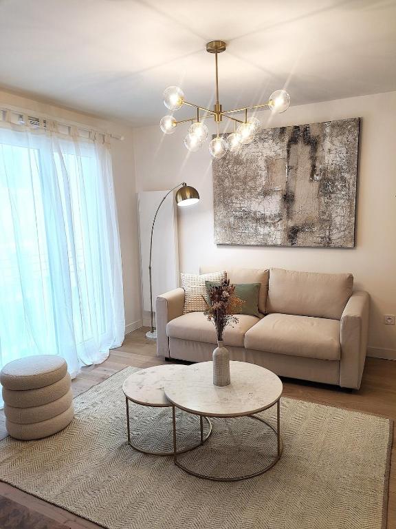 un salon avec un canapé et une table dans l'établissement Appartement élégant proche Paris, à Clichy