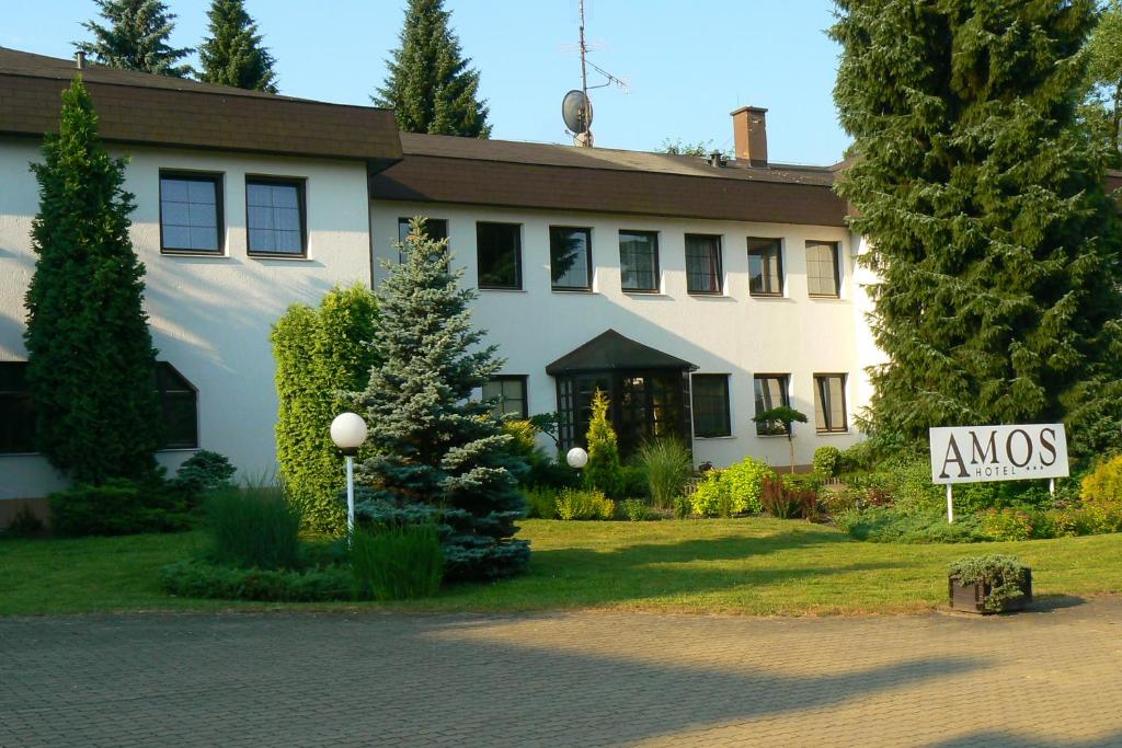 a large white house with a sign in front of it at Hotel Amos in Fulnek