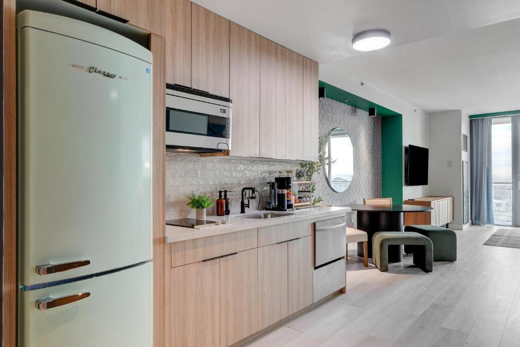 a kitchen with a white refrigerator and a sink at 37th FLOOR STUDIO STRIP VIEW Palm Place Resort in Las Vegas