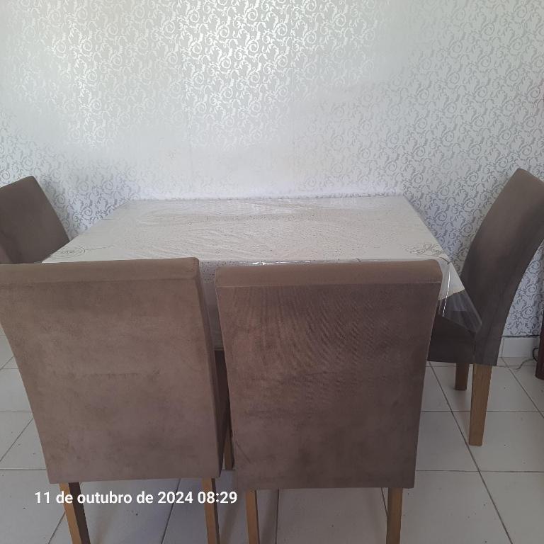 a table with two chairs and a white table cloth on it at Ambiente Familiar in Alagoinhas