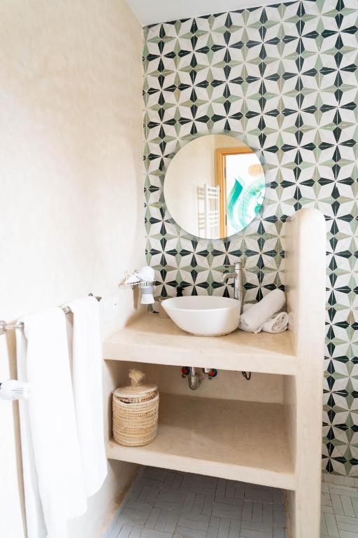 a bathroom with a sink and a mirror at RIAD OASIS D'ASILAH in Asilah