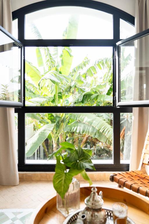a window with a plant in a vase on a table at RIAD OASIS D'ASILAH in Asilah