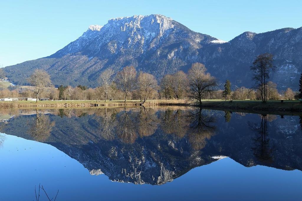 a mountain reflection in a lake with a mountain at Alpenblick - Zentralgelegene 2-Zimmer-Wohnung in Kiefersfelden