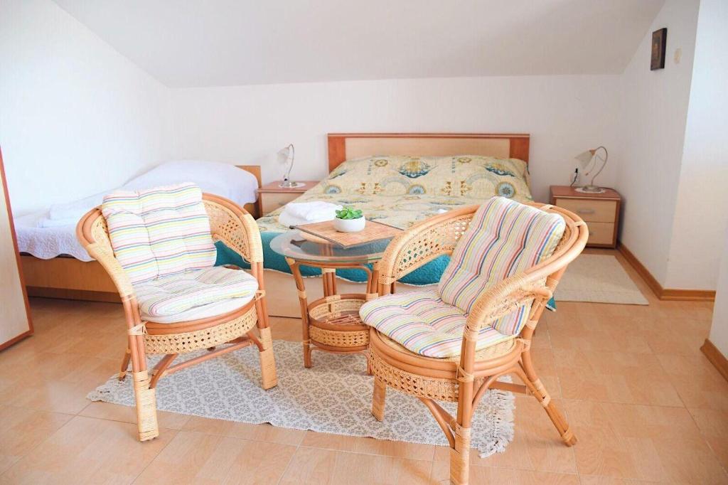 Pokój ze stołem, 2 krzesłami i łóżkiem w obiekcie Apartments Darko w Sukošanie