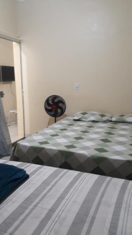 a bedroom with a bed with a green and white comforter at Porto apartamento in Porto Seguro