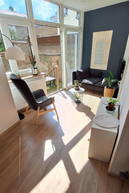 un salon avec une chaise et un canapé dans l'établissement Le Fiacre, à Nancy