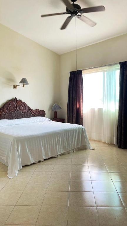 a bedroom with a bed and a ceiling fan at Delfin in Cruz de Huanacaxtle