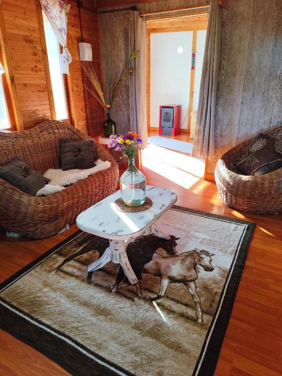 克利翁Cabaña en Quellón的客厅配有桌子,马匹在地毯上
