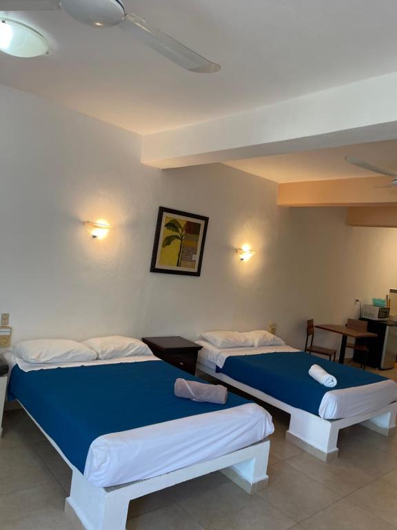 a room with two beds and a table at Condo Marena in Playa del Carmen