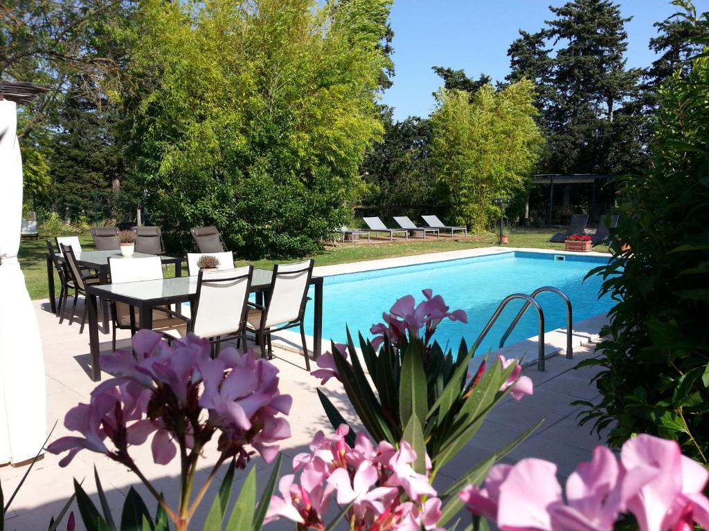 un patio con mesa y sillas junto a una piscina en Mas la Provence, en LʼIsle-sur-la-Sorgue