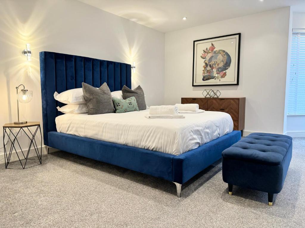 a large bed with a blue headboard and a blue chair at Eagles Cottage, 3 - Bed, Sleeps 6, Pets Welcome - Ulverston in Ulverston