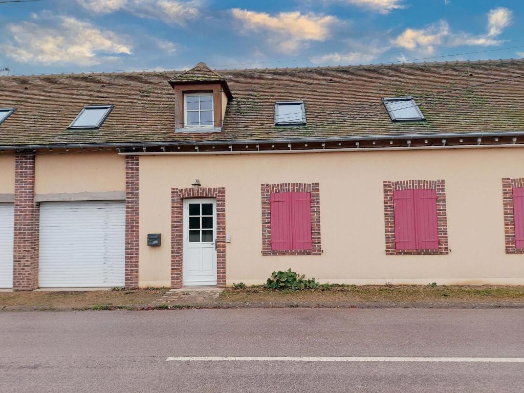ein Haus mit roten Fensterläden auf einer Straße in der Unterkunft Appartement cosy rénové près de Chartres - FR-1-581-147 in Le Boullay-Thierry