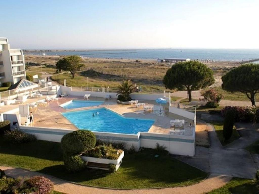 - une vue aérienne sur la piscine d'un complexe dans l'établissement Appartement 3 pièces pour 6 avec piscine, WIFI, et parking à Port Camargue - FR-1-731-108, au Grau-du-Roi
