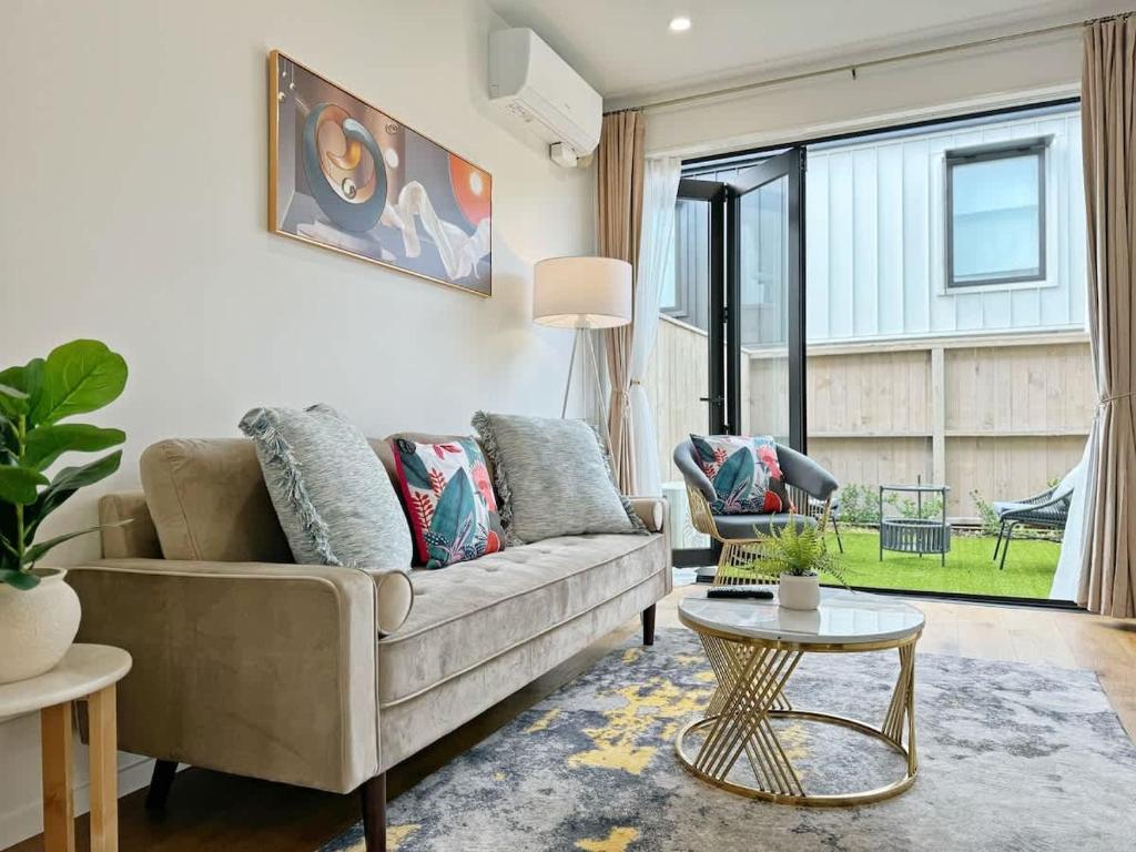 una sala de estar con un sofá y una mesa en City & Ponsonby Center Side 2 BDR Townhouse vs AC, en Auckland