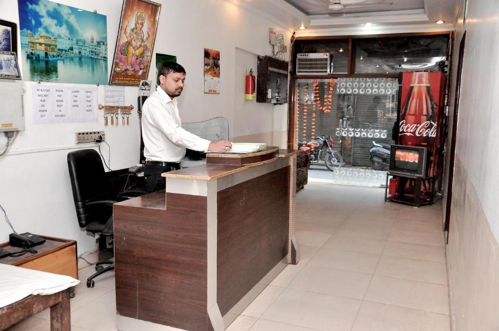 un hombre parado en un mostrador en una cafetería en Asha Guest House en Amritsar