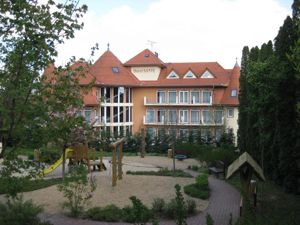 ein großes Gebäude mit einem Spielplatz davor in der Unterkunft SANTE Hévíz in Hévíz