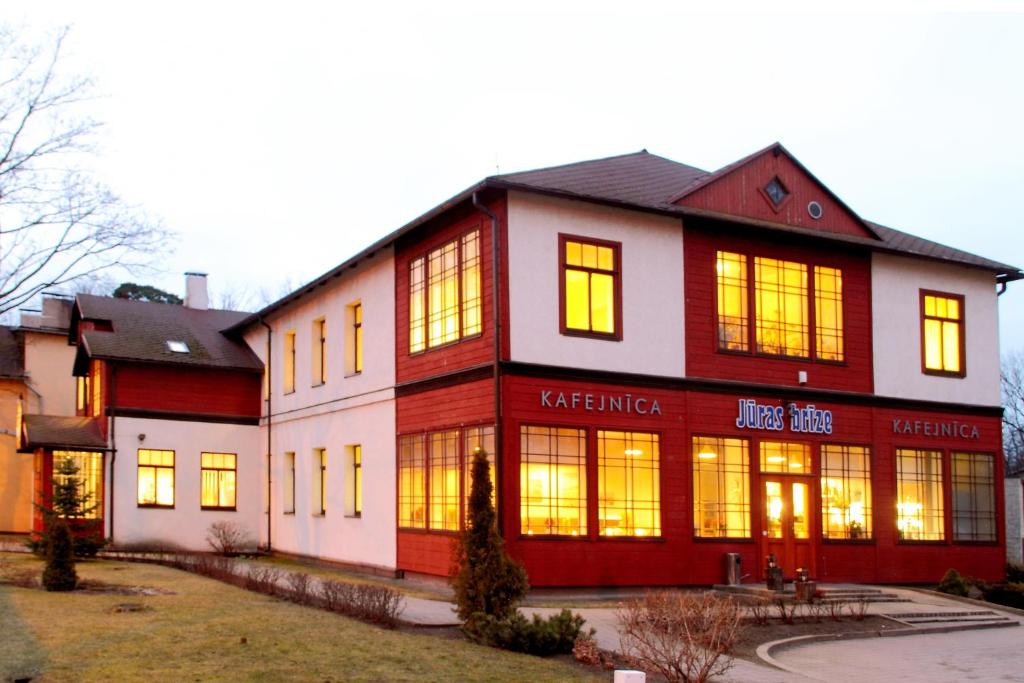 a large building with lights on in the windows at Jūras Brīze in Ventspils