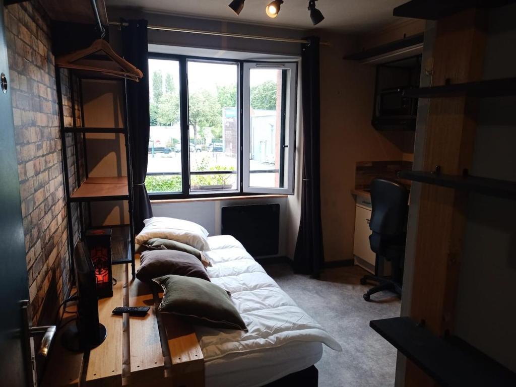 une chambre avec quatre lits avec oreillers et une fenêtre dans l'établissement republic studio, à Nantes