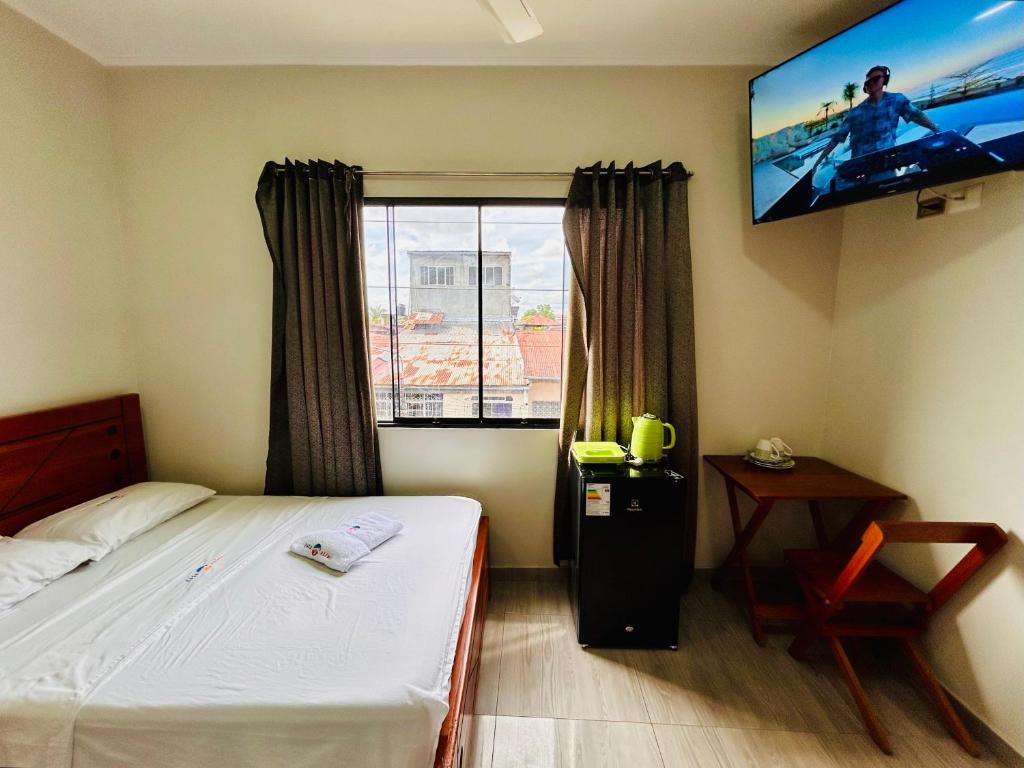 una camera da letto con un letto e una TV a schermo piatto di Habitación Céntrica en Iquitos - Casa Alemi 14 a Iquitos