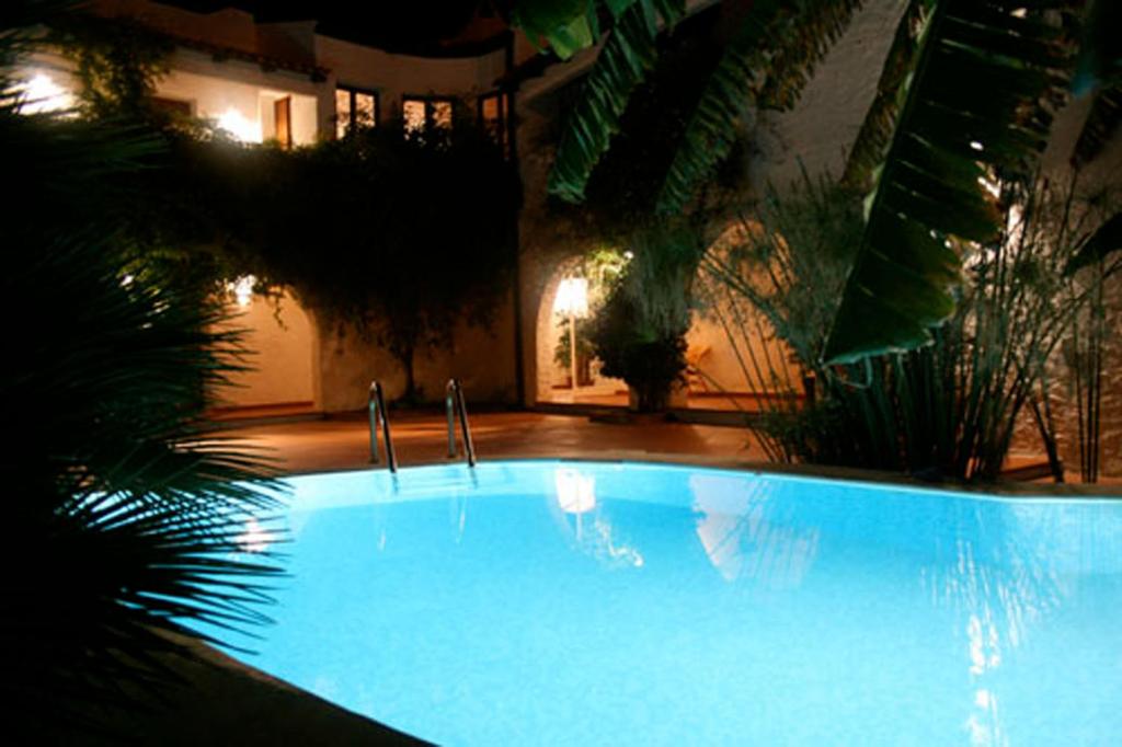 a large blue swimming pool in front of a building at Hotel Villa Mediterranea in Noto Marina