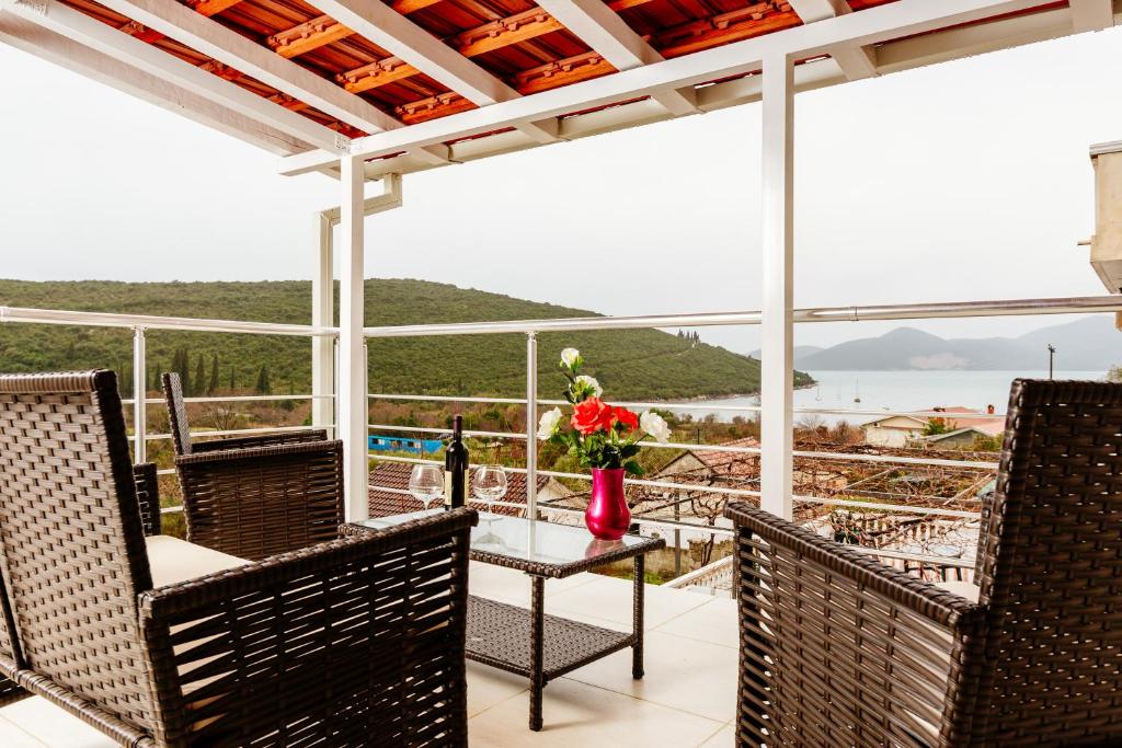 a patio with chairs and a table with a vase of flowers at Bigova Sea Views Apartments in Tivat