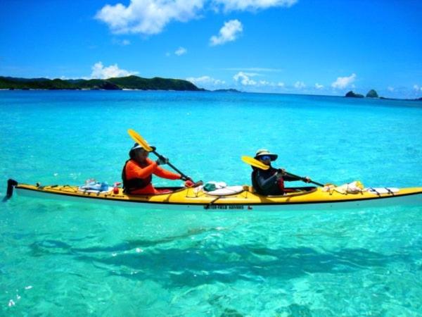 two people in a yellow kayak in the water at Cha Villa in Zamami