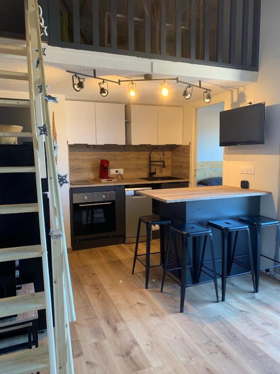 une cuisine avec un comptoir bleu et des tabourets dans l'établissement Appartement charme 5 personnes, à Saint Cyprien Plage