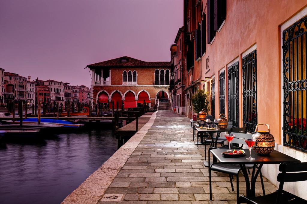 ヴェネツィアにあるHotel L'Orologio - WTB Hotelsのテーブルと椅子が並ぶ運河