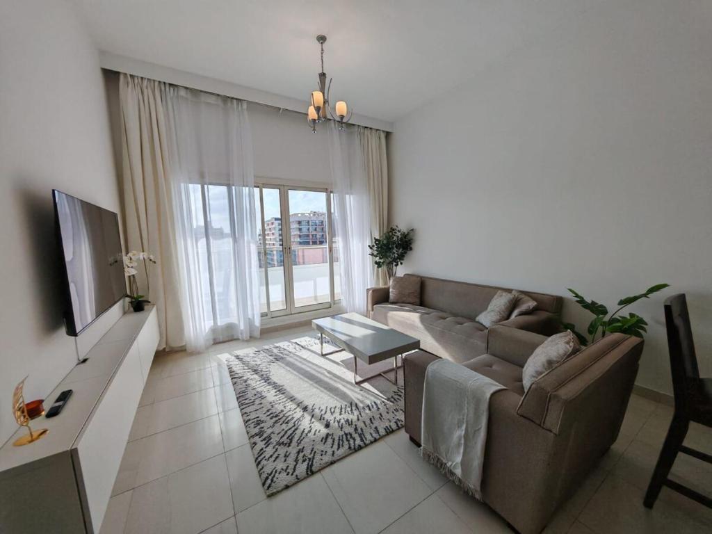 a living room with a couch and a tv at Silicon Heights II in Dubai