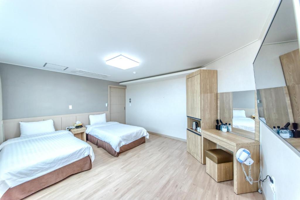 Postel nebo postele na pokoji v ubytování Jungmoon City Hotel & J-hill Hotel