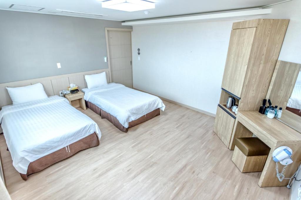 Postel nebo postele na pokoji v ubytování Jungmoon City Hotel & J-hill Hotel
