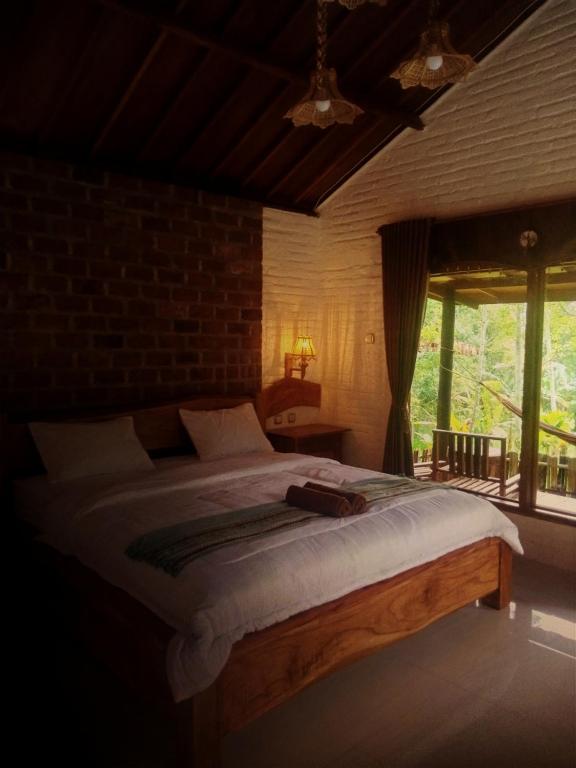 a bedroom with a bed and a large window at Mimi homestay-LOMBOK in Tetebatu