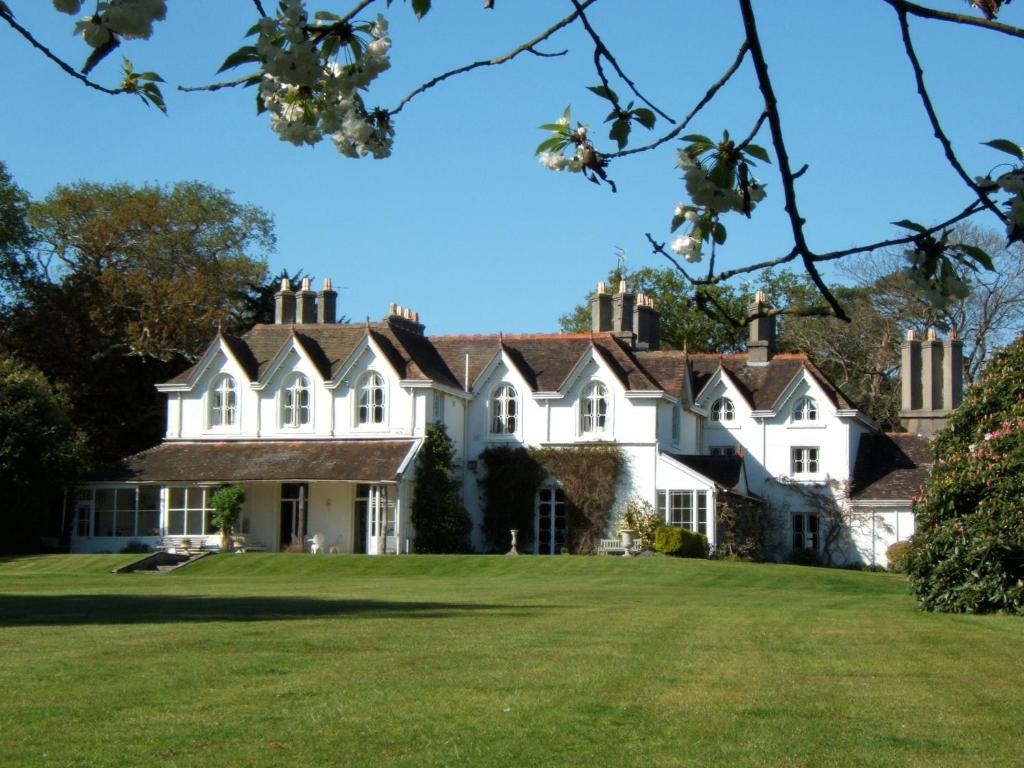 uma grande casa branca com um grande relvado em Hollybank House em Emsworth