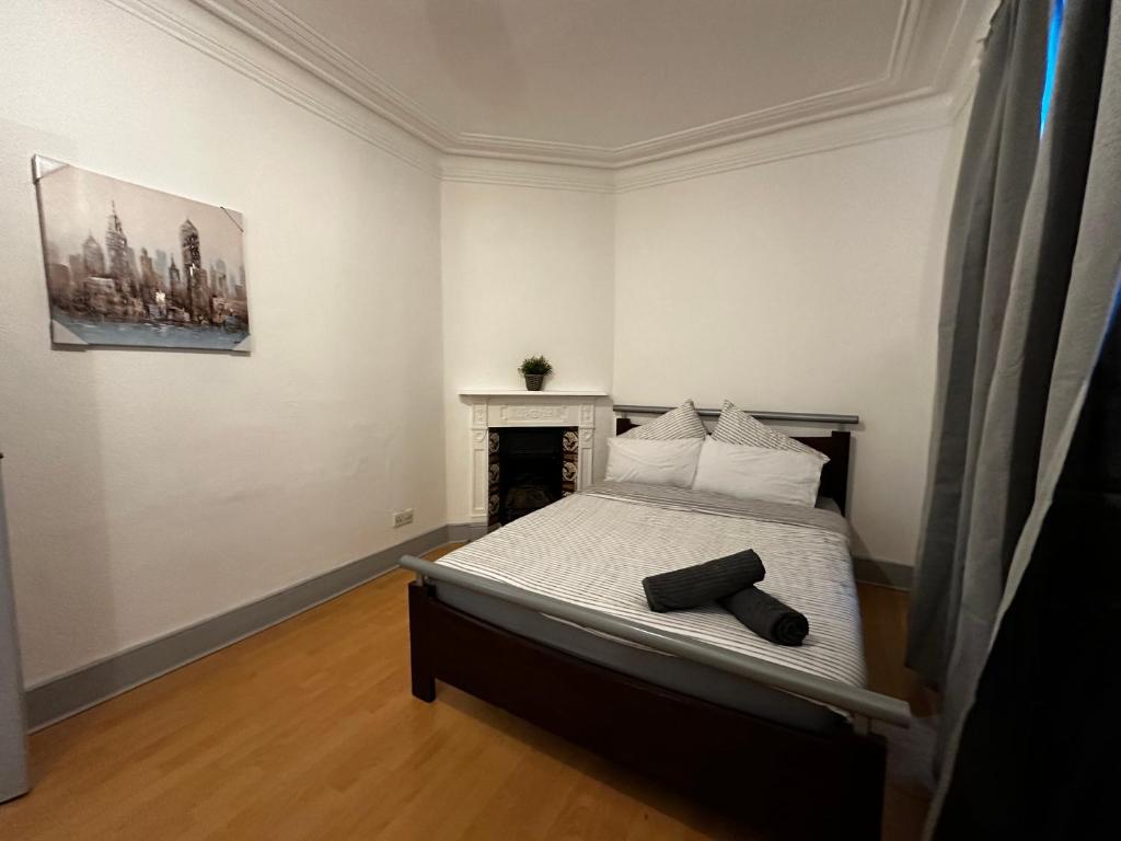 a bedroom with a bed and a painting on the wall at Grove Rooms 2 in London