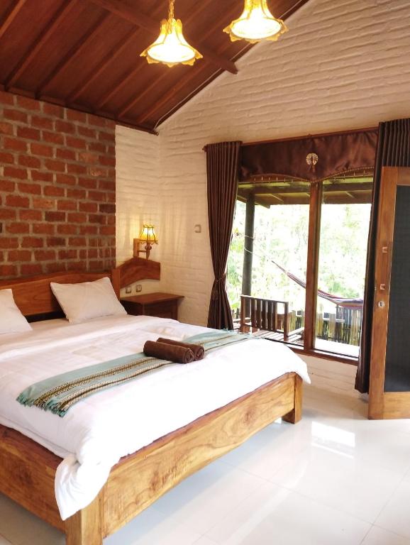 a bedroom with a bed and a large window at Mimi homestay-LOMBOK in Tetebatu