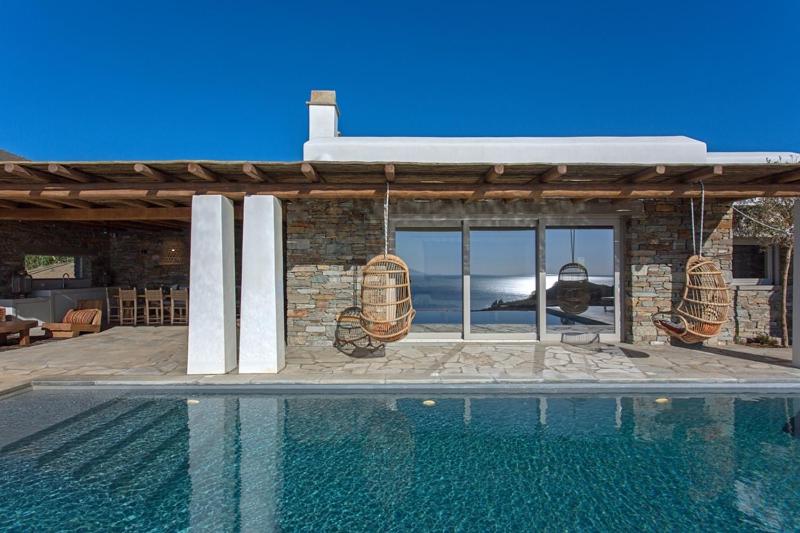 a house with a swimming pool in front of a building at Villa Meltemi in Kardiani
