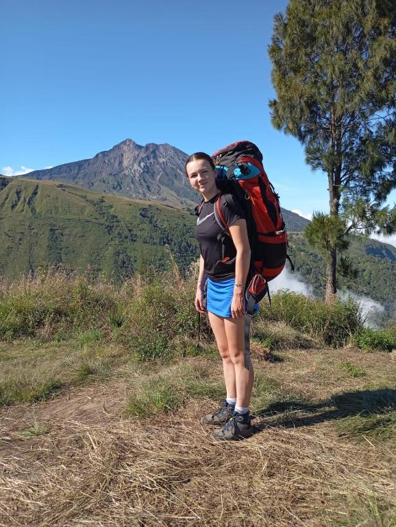a woman standing on a hill with a backpack at Mimi homestay-LOMBOK in Tetebatu