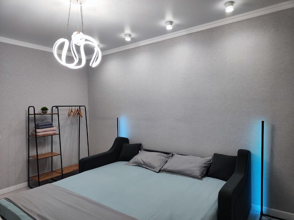 a bedroom with a bed and a chandelier at 2-х комнатная квартира in Kokshetau