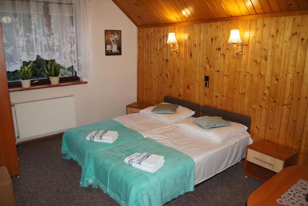 a bedroom with a bed with towels on it at Róża in Szklarska Poręba