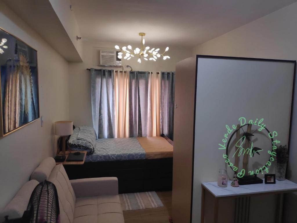 a small bedroom with a bed and a chandelier at Paseo Verde Daily Staycation in Manila